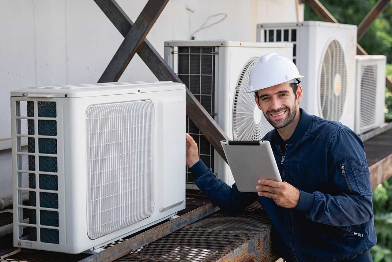 Professional technician installing a modern wall-mounted air conditioning unit in a residential property in London.