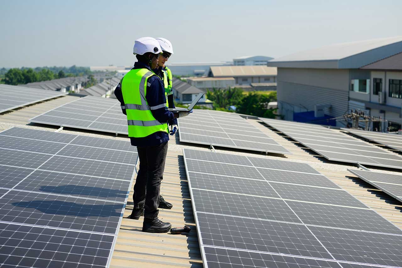 Technician performing a detailed solar panel inspection on a rooftop photovoltaic system using professional testing equipment to assess performance, safety, and efficiency
