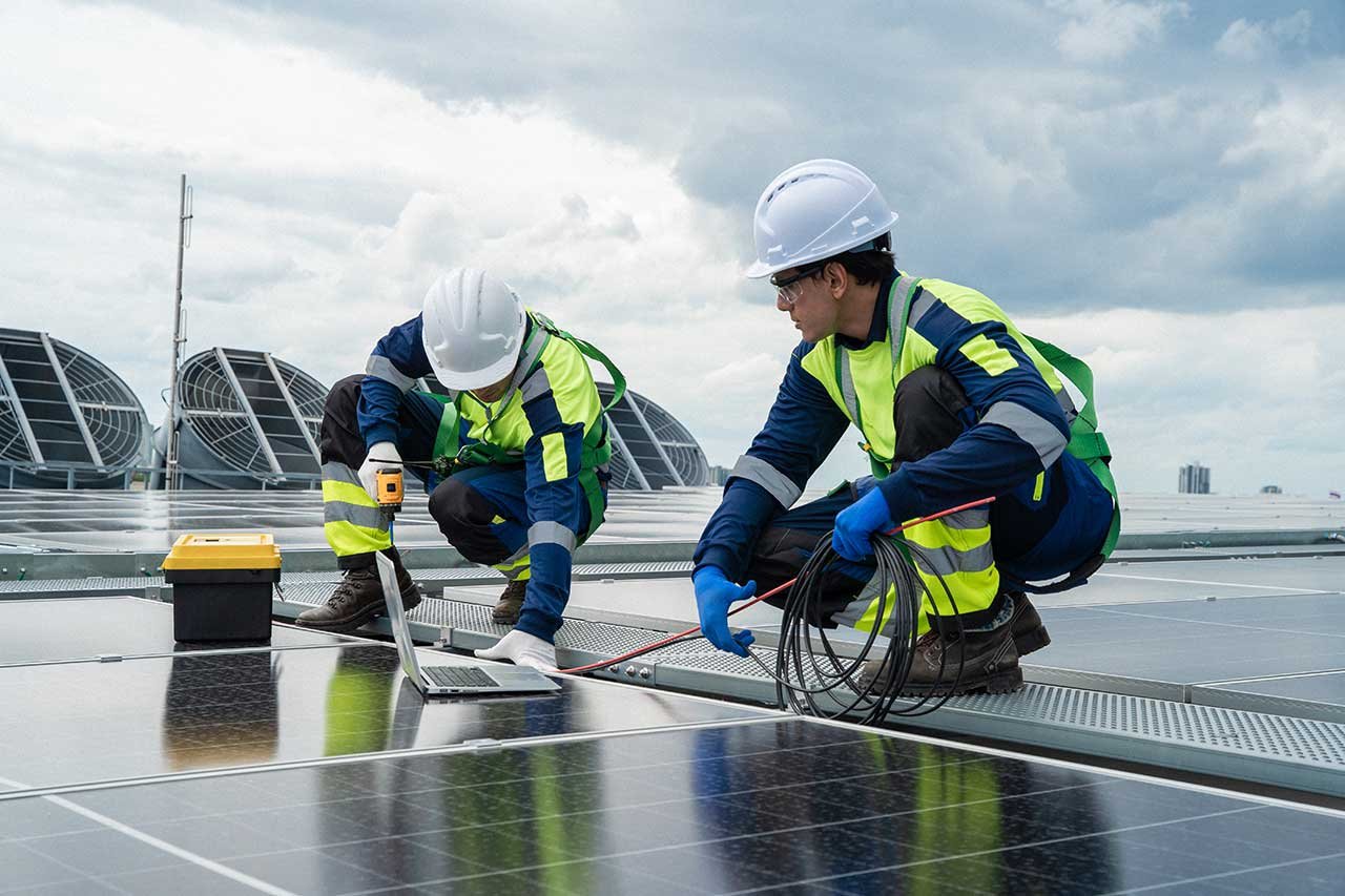 Technician repairing and maintaining a residential solar panel system on a rooftop in London.